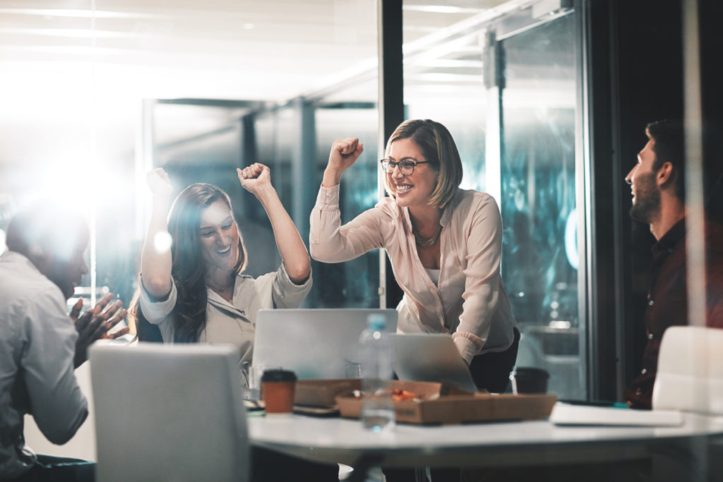 Shot of colleagues celebrating during a meeting in a modern office